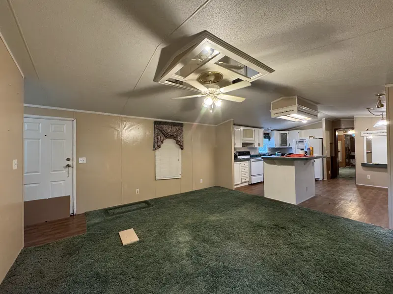 Living room with front door and kitchen view