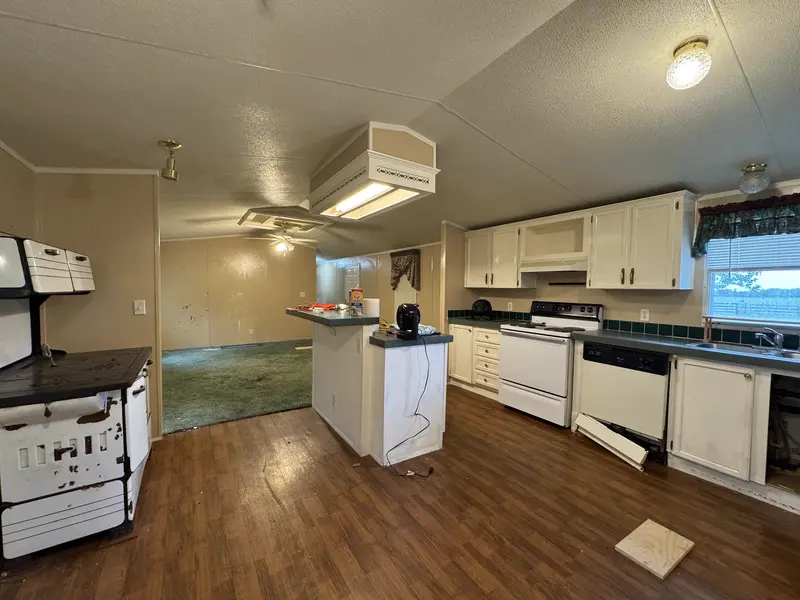 Full kitchen with white cabinets and island