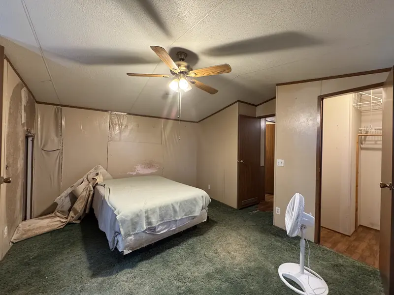 Master bedroom with ceiling fan and walk-in closet
