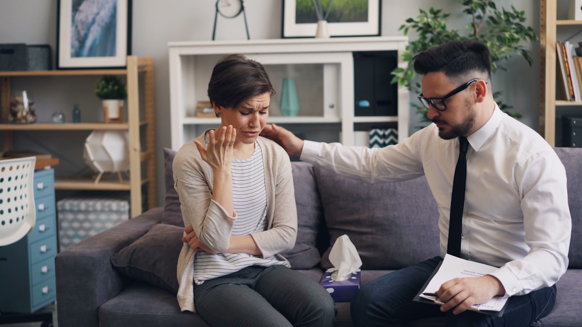 Stressed couple sitting on couch reviewing divorce documents